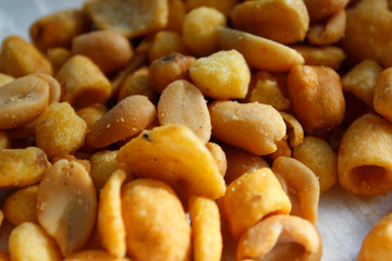 Golden mixed nuts, snacks, chips for beer close-up with selective focus.