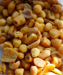 Golden mixed nuts, snacks, chips for beer close-up with selective focus.