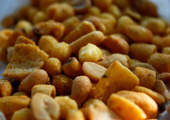 Golden mixed nuts, snacks, chips for beer close-up with selective focus.
