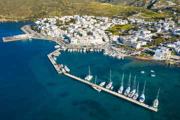 aerial view to to marine and pier with little port city on greek island