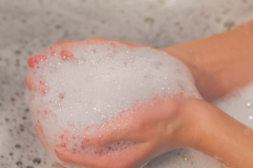 Fototapeta premium Soap foam on hands in bath. concept of purity
