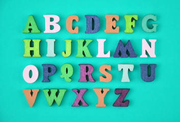English alphabet made of multi-colored wooden letters on blue background