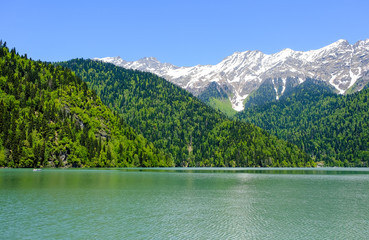 View of lake Ritsa (Riza) in Abkhazia in the spring, in the background snow-capped mountains 