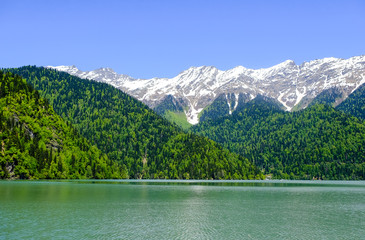 View of lake Ritsa (Riza) in Abkhazia in the spring, in the background snow-capped mountains 