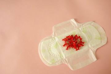 Menstrual pad with red pins on pink background, copy space for your design