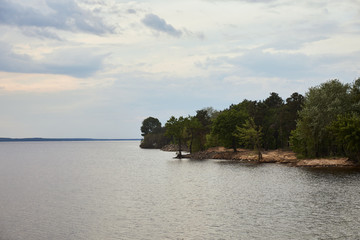 view of white sky, river and forest on coast
