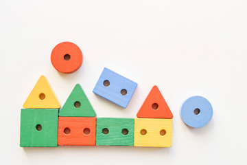 Wooden houses is made of toy blocks on a white background