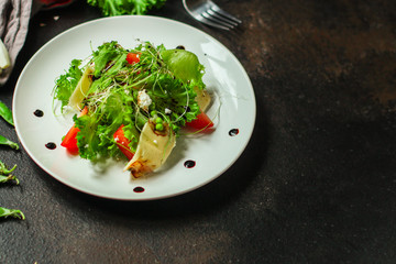 salad vegetables - tomato, lettuce, cheese, microgreen and salad dressing. food background. top