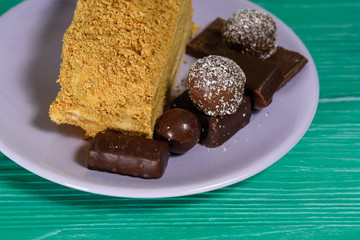 Homemade pastries and chocolates on a ceramic plate on a wooden background.
