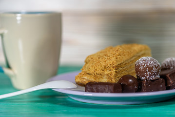 Homemade pastries and chocolates on a ceramic plate on a wooden background.