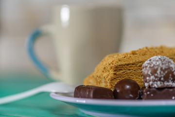 Homemade pastries and chocolates on a ceramic plate on a wooden background.