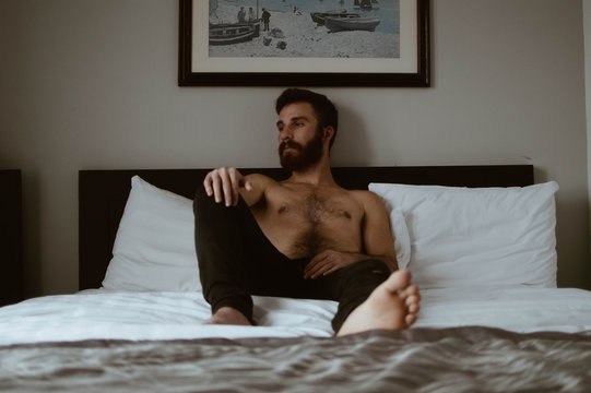 bearded man lying on bed