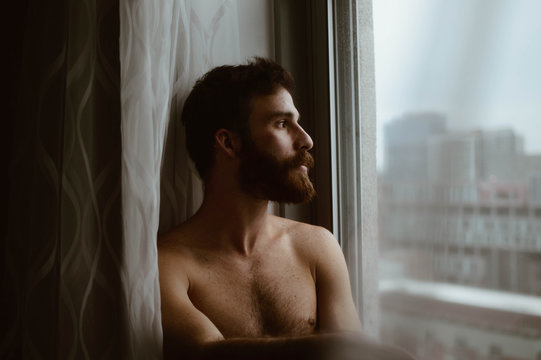 man leaning beside window