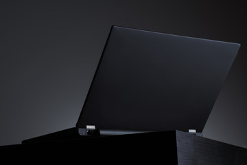 Business laptop with gray background on the black wooden table  