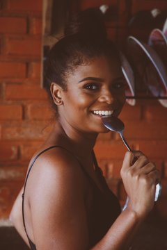 smiling woman holding silver spoon