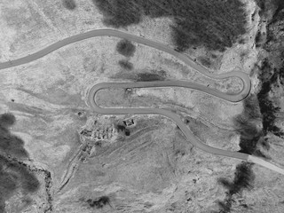 Fototapeta premium Winding mountain road to turn, autumn forest. Aerial top view