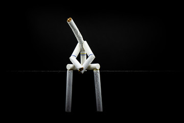 image of a character made of cigarette, alone and sad with black background. Concept of addiction in smoking, smoker wanting to stop smoking but with difuculty.