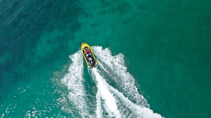 Aerial drone top view photo of jet ski cruising in high speed in emerald exotic tropical bay