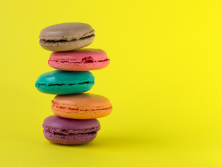 Sweet french macaroons cake on the yellow background.