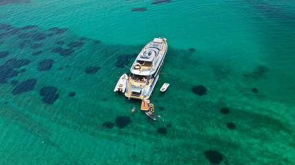 Aerial drone top view photo of large yacht - boat docked in tropical exotic paradise bay with emerald open ocean