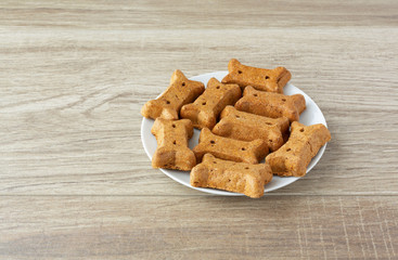 Side view of peanut butter dog biscuits on a white plate