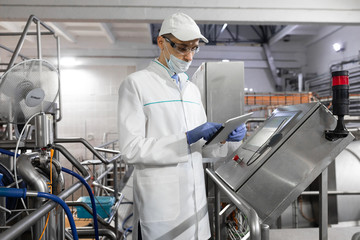 man in a white robe and a cap make a configure the digital screen