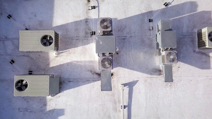 Air conditioning units on top of building in aerial top view.