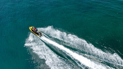 Aerial drone top view photo of jet ski cruising in high speed in emerald exotic tropical bay
