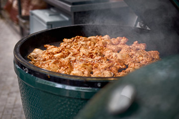 Open grill, meat roasts on fire with smoke. Cooking outside. Street market, street trading, healthy food. Selective focus