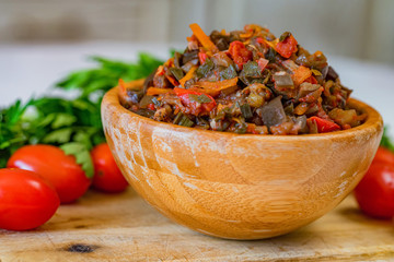 Close up home made aubergine pate or spread in wooden bowl