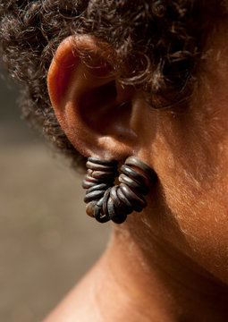 Little Girl Wearing Ear Rings Made With Turtle Shells, Trobriand Island, Papua New Guinea