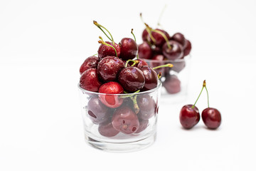 Fresh organic ripe cherries in the glass bowl isolated on white background