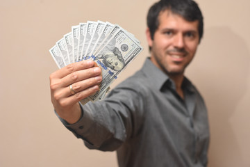 Concept of success, Young businessman with lot of money. Pile of dollars in a man hand