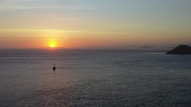 A small pinisi schooner sails at dawn in Komodo National Park, Indonesia. This tropical area is known for both its marine biodiversity as well as its infamous dragons.