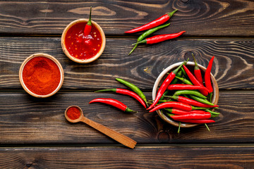 Fresh red chilli pepper and dry powder as food ingredient on wooden table background top view