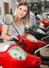 Fototapeta na wymiar Young female is choosing modern motobikes