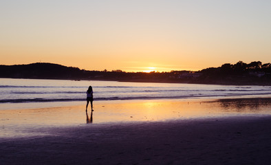Fototapeta na wymiar Woman walking on the beach of La Lanzada, O Grove, Pontevedra, Galicia, Spain. No people.