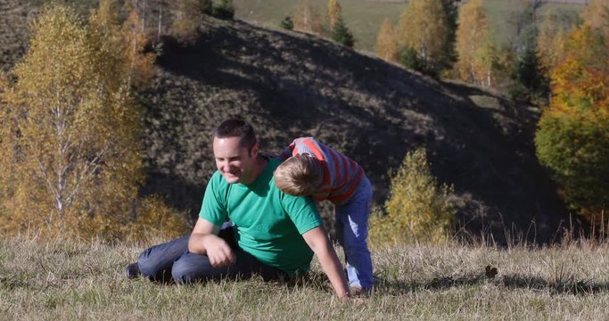 Happy father and little son play in nature, beautiful autumn landscape