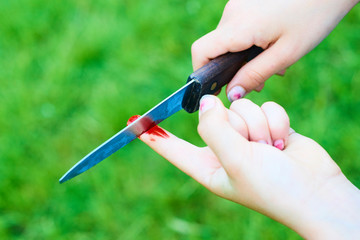 Accident wounded on finger with blood and knife. Child playing with knife