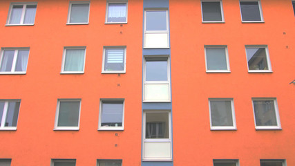 Fototapeta premium orange colorful building facade with windows. modern german european architecture style.