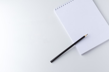 Notepad with pencils on white table