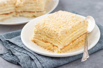 Layered cake with cream Napoleon millefeuille vanilla slice on a white plate.