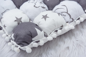 Decorative children's mattress for newborns. Bedding for a baby cot. The mattress is gray and white.