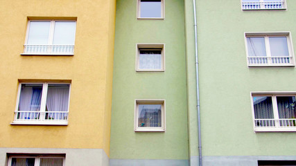 Obraz premium yellow and green color colorful building facade with windows. modern german european architecture style.