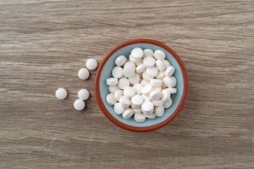 DHEA pills in a bowl on a table top view