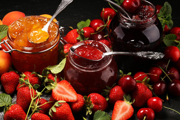 assortment of jams, seasonal berries, apricot, mint and fruits. marmalade or confiture