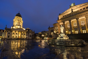 Obraz premium Illuminated Schiller Monument, facade of the Neue Kirche (Deutscher Dom, German Church or German Cathedral) and Konzerthaus Berlin (Berlin Concert Hall) at the Gendarmenmarkt Square in Berlin at dusk.