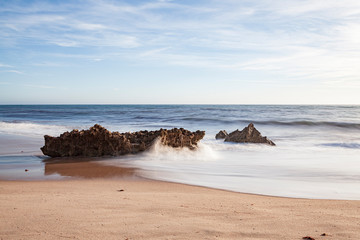 Fototapeta na wymiar Rochas na rebentação das ondas, no areal da praia, na “Praia da Ilha” em Porto Covo (Costa Vicentina), Alentejo, Portugal, Europa.