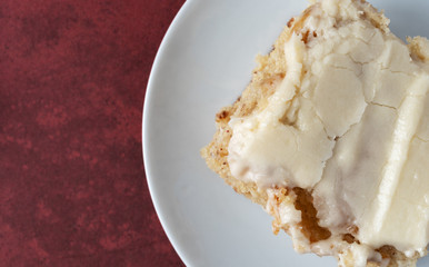 Serving of banana bread with icing on a plate top close view