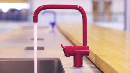 water from red faucet in public kitchen
